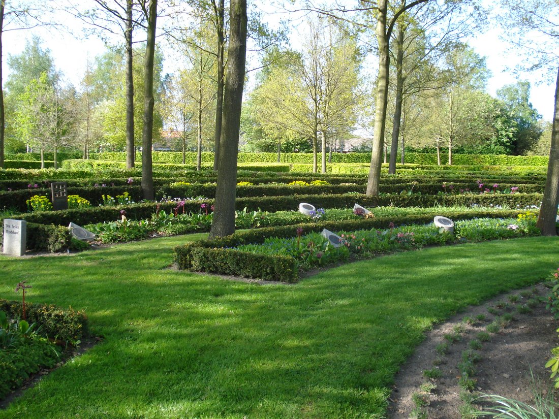 Kirkegård med gravpladser og beplantning placeret i halvcirkler.